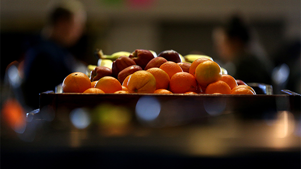 Fruit basket on table with apples, oranges and bananas